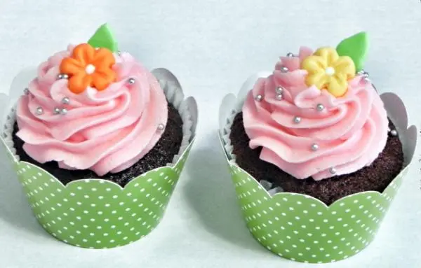 Cupcake de Chocolate, Recheado com Cobertura de Chantilly Rosa e Decorado com Florzinhas em Pasta Americana